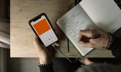 Person listening to a podcast whilst taking notes